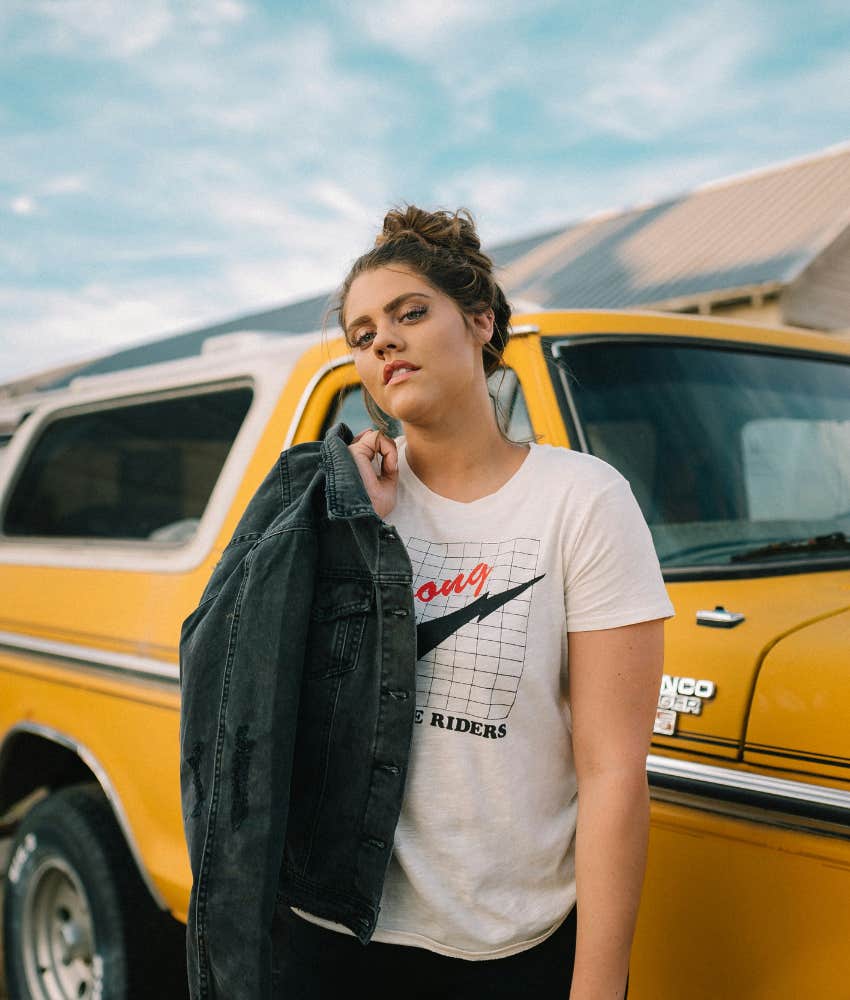teenager standing next to yellow ford bronce