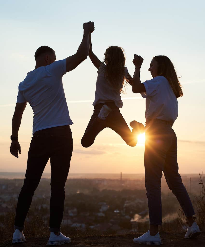parents lift child by each arm